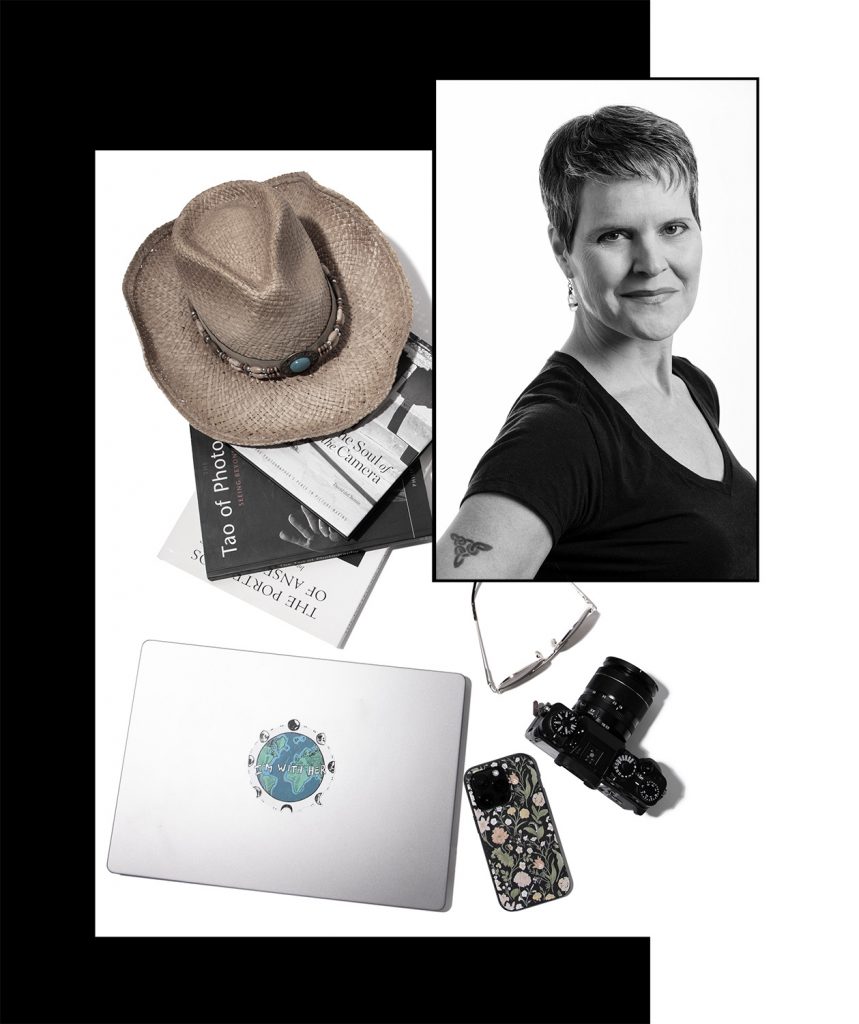 portrait of woman with background of flat lay of camera iphone laptop books cowboy hat