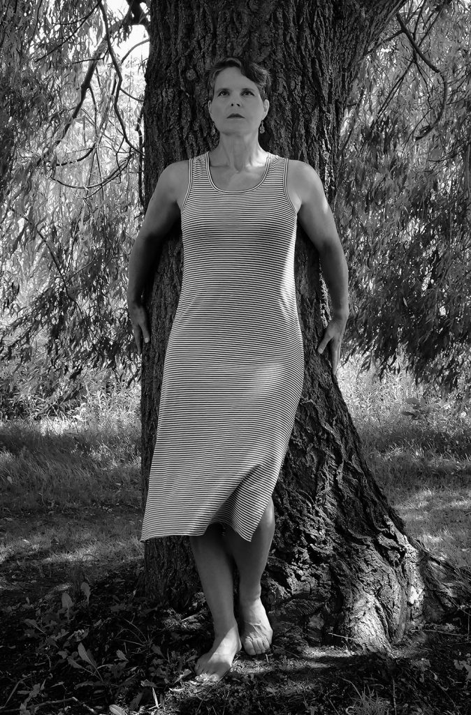 professional creative portrait of mature woman standing in front of tree
